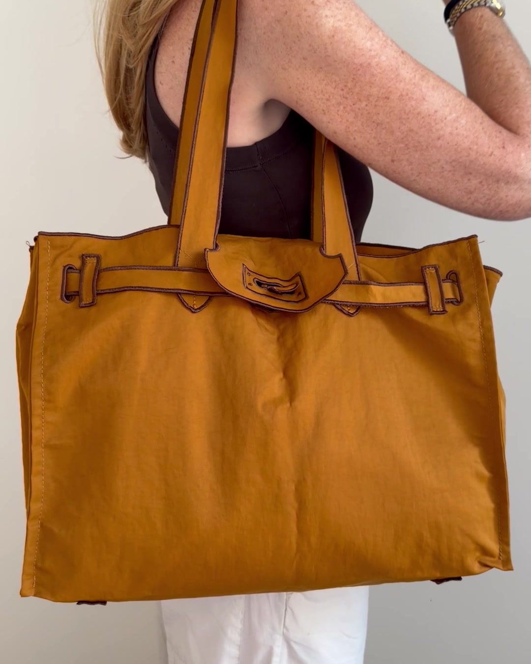 Bolso ligero XL color ocre llevado al hombro