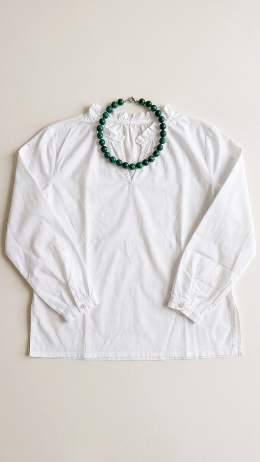 Collar de malaquita natural de 46 cm sobre camisa blanca para mostrar su proporción